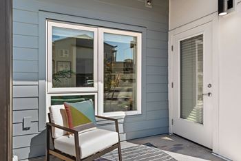 A porch with a chair and a window